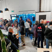 Load image into Gallery viewer, A great group of people hanging out in our taproom drinking beer